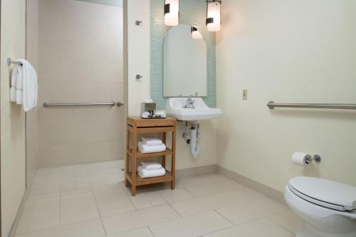 a bathroom with a sink and a toilet and a mirror at Toll House Hotel Los Gatos in Los Gatos