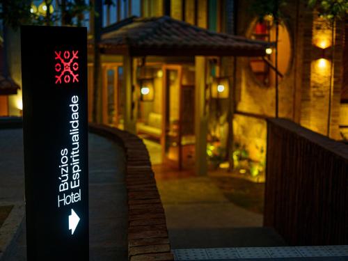 a sign on a sidewalk in front of a building at Buzios Espiritualidade Hotel in Búzios