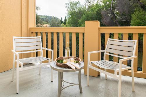two chairs and a table with a bottle of wine on a porch at Toll House Hotel Los Gatos in Los Gatos
