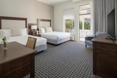 a hotel room with two beds and a television at Toll House Hotel Los Gatos in Los Gatos