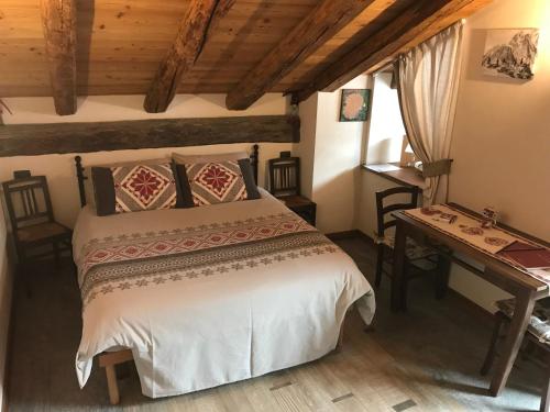 una camera con un grande letto e una scrivania di La Maison du Pont Mont Blanc 2 a La Salle