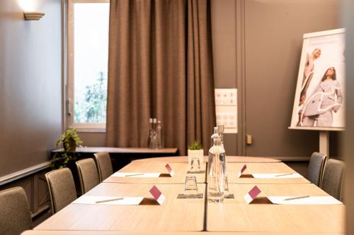 a conference room with a long wooden table and chairs at Mercure Grenoble Meylan in Meylan