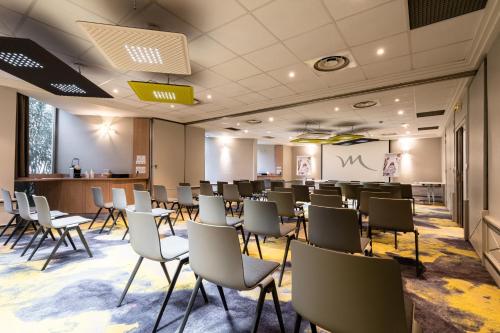a conference room with chairs and a bar at Mercure Grenoble Meylan in Meylan