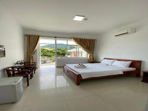 a bedroom with a bed and a large window at Con Dao Guesthouse in Con Dao