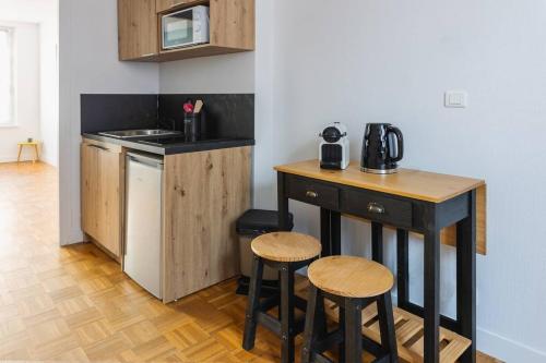 - une cuisine avec un comptoir et des tabourets dans une pièce dans l'établissement Joli T2 rénové 'Pinot Noir' plein centre village, à Hautvillers