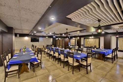 un comedor con mesas y sillas azules en hotel puneet international, en Raipur