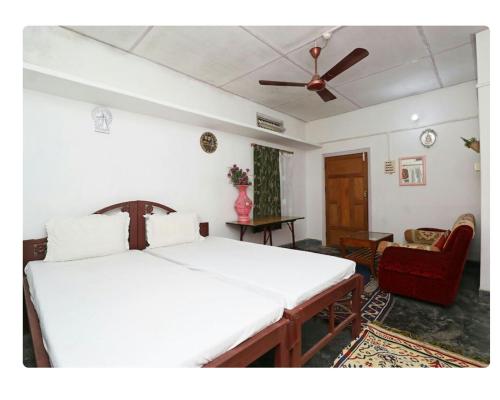 a bedroom with a bed and a ceiling fan at Rupali Tat Ghar and Homestay in Majuli