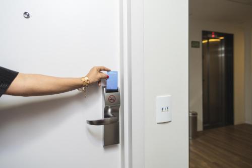 a person is unlocking a door with a cell phone at Tulip Inn Vila Velha in Vila Velha
