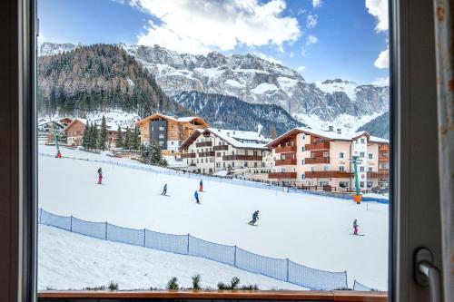 a group of people skiing down a snow covered mountain at Garni Bondi in Selva di Val Gardena