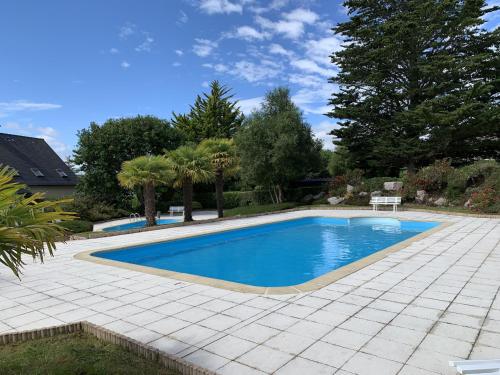 une piscine dans une cour avec un patio dans l'établissement Maison pour 6 à Erquy - Piscine collective, à Erquy