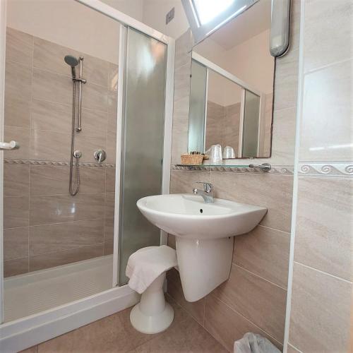 a bathroom with a white sink and a shower at Hotel Ornella in Lido di Jesolo