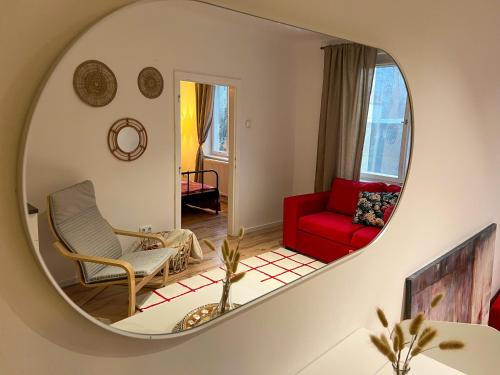 Cosy brand new Apartment في فيينا: غرفة معيشة مع أريكة حمراء ومرآة