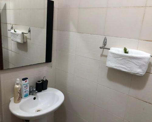 a white bathroom with a sink and a mirror at Two bedroom Apartment in Oyster Bay in Dar es Salaam