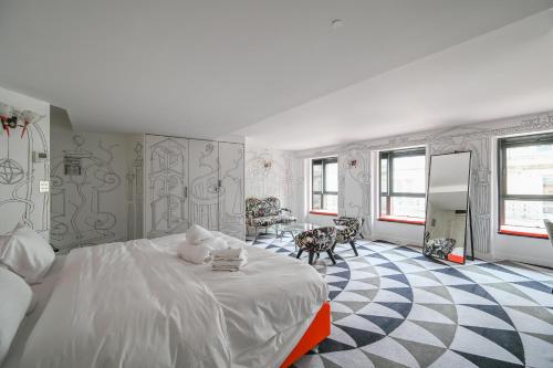 ein Schlafzimmer mit einem großen weißen Bett und ein Zimmer mit Stühlen in der Unterkunft Magic suite in Saint Germain des Près (Montana5) in Paris