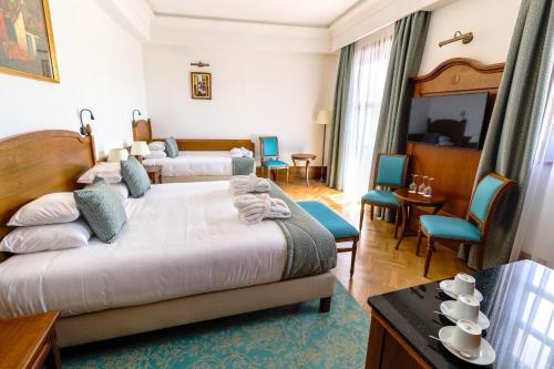 ein Hotelzimmer mit 2 Betten, einem Tisch und Stühlen in der Unterkunft Hungarikum Hotel in Lakitelek