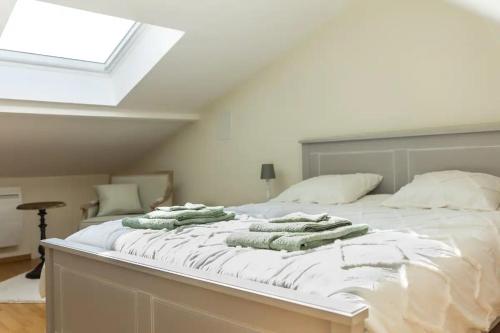 Un dormitorio con una cama blanca con almohadas. en Maison 'Millésime' spacieuse et confortable, en Hautvillers