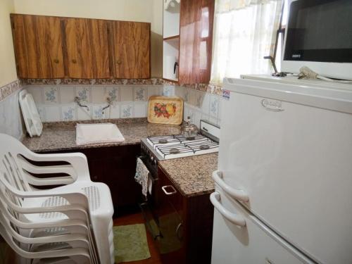 una pequeña cocina con fogones y nevera. en HERMINIA en Villa Carlos Paz