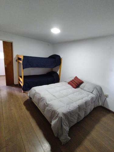 1 dormitorio con 1 cama y 1 silla azul en Departamentos Patico en Santa Rosa de Calamuchita