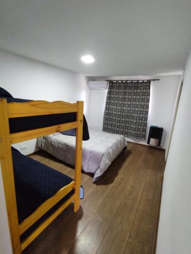 1 dormitorio con 2 literas y ventana en Departamentos Patico en Santa Rosa de Calamuchita