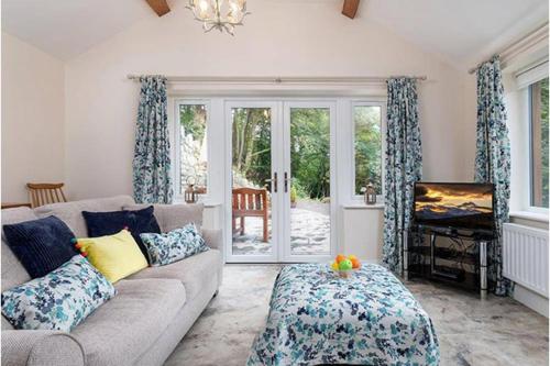 a living room with a couch and a sliding glass door at Beudy Bach in Llanrwst