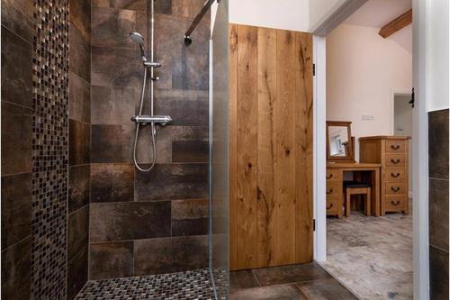 a bathroom with a shower with a glass door at Beudy Bach in Llanrwst