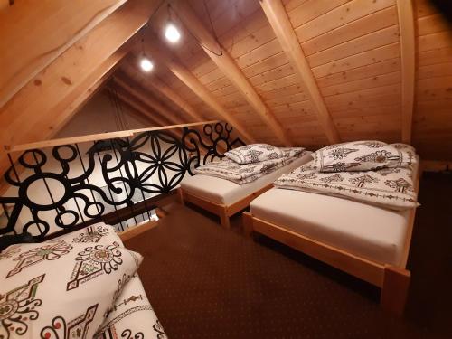 a room with two beds in a attic at Domek na szlaku RIKARDO in Ponice