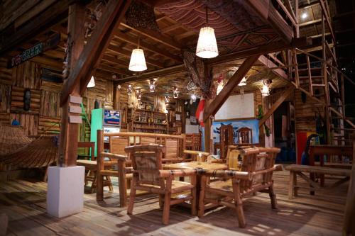 een eetkamer met houten tafels en stoelen bij Green Hill Restaurant & Cottages in San Vicente