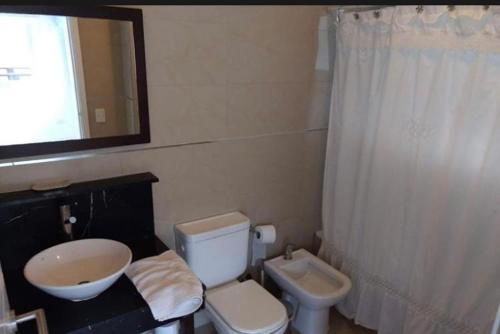 Łazienka z białą toaletą i umywalką w obiekcie Linda Bay Beach & Resort Studio 304 w mieście Mar de las Pampas