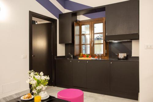 a kitchen with black cabinets and a purple ceiling at Casual Rinascimento Firenze in Florence