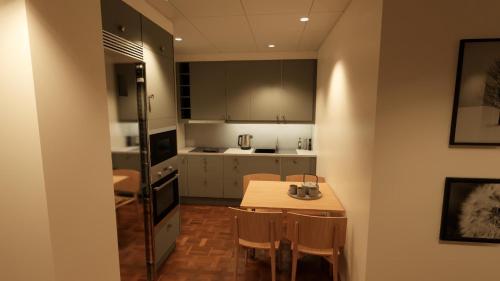 La cuisine est équipée d'une table, de chaises et d'un réfrigérateur. dans l'établissement Esplanad Suites, à Mariehamn