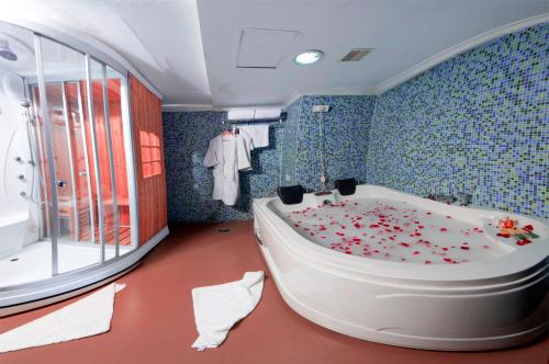uma casa de banho com uma banheira coberta de flores em The Quilon Beach Hotel and Convention Center em Kollam