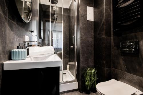 PiotrApartments Luxury Apartments in City Centre في وارسو: حمام مع حوض ومرحاض