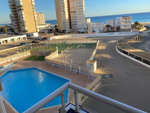 una piscina en la parte superior de un edificio con el océano en Apartamento Geminis, en La Manga del Mar Menor