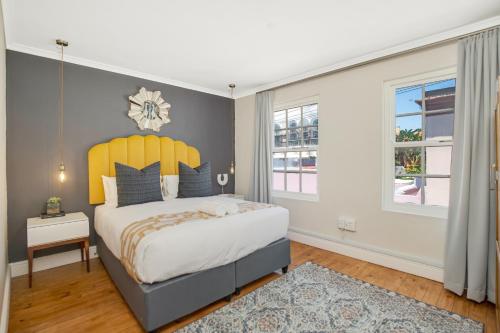 a bedroom with a large bed with a yellow headboard at Shortmarket 136 in Cape Town