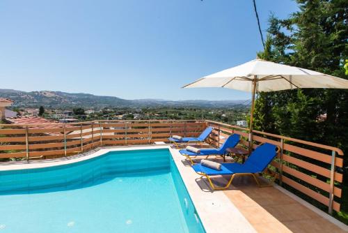 a swimming pool with two chairs and an umbrella at Bezari pool villa in Metochia Fratzeskiana
