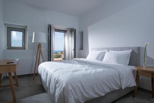 Schlafzimmer mit einem großen weißen Bett und einem Fenster in der Unterkunft HERMIONE 3-Bedroom Villa in Agios Nikolaos in Agios Nikolaos