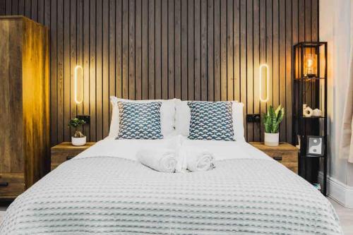 a bedroom with a large bed with blue and white pillows at Modern 2 bed flat near Wembley Stadium in London