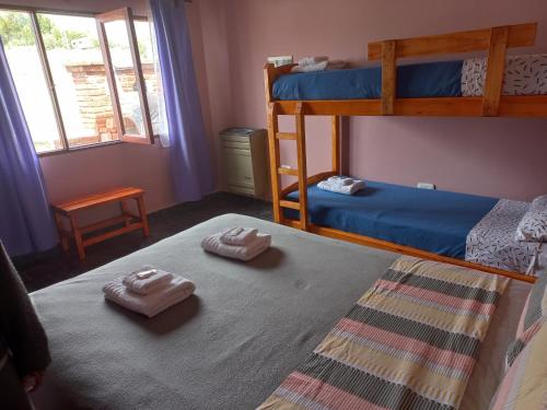 1 dormitorio con 2 literas y toallas en el suelo en Las cuatro Hermanas2 en El Calafate