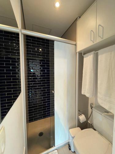 a bathroom with a toilet and a glass shower at Unique (Ex-Estanconfor) veja o mar do apto 2302 in Santos
