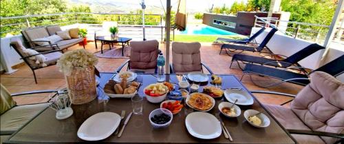 a table with plates of food on a patio at Magical Andalusian Vacation "Los Arcos" in Tózar
