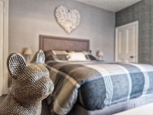 a bedroom with a bed with a cat statue in front of it at Bounty Town House Cumbria in Whitehaven