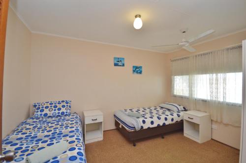 a bedroom with two beds and a window at Red Rock Retreat C - Kalbarri WA in Kalbarri