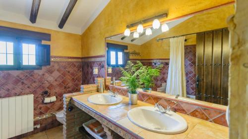 a bathroom with two sinks and a large mirror at Combinación Cortijo y Mirador Casablanca Priego de Córdoba by Ruralidays in Priego de Córdoba