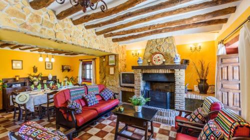 a living room with a red couch and a fireplace at Combinación Cortijo y Mirador Casablanca Priego de Córdoba by Ruralidays in Priego de Córdoba