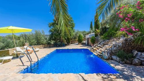a swimming pool in a yard with an umbrella at Combinación Cortijo y Mirador Casablanca Priego de Córdoba by Ruralidays in Priego de Córdoba