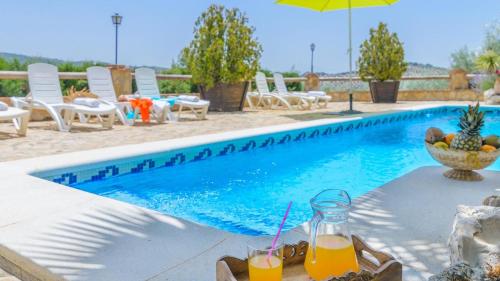 a table with two glasses of orange juice next to a swimming pool at Combinación Cortijo y Mirador Casablanca Priego de Córdoba by Ruralidays in Priego de Córdoba