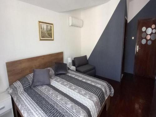 ein kleines Schlafzimmer mit einem Bett und einem Stuhl in der Unterkunft Rooms Providenca in Gradac