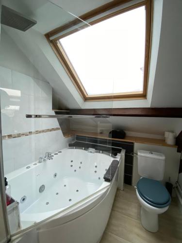 a bathroom with a large tub and a toilet at Les appartements d'Au Coin Du Spa in Boulogne-sur-Mer