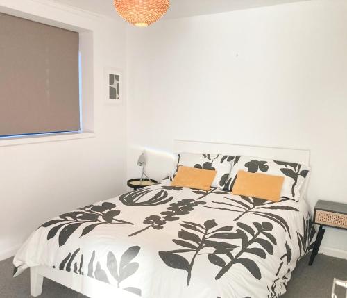 a bedroom with a black and white bed with two pillows at Philippa Court Grade II townhouse- 3 bedrooms- free parking in Norwich