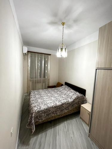 a bedroom with a bed and a chandelier at Апартаменты с тремя спальнями in Yerevan